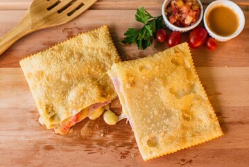 A closeup shot of fried dough with ham and cheese