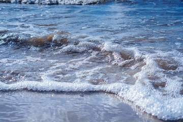Sea waves and tide with foam. Natural condition, water arrival, breaking wave in turquoise sea or ocean surface, summer