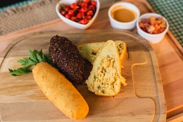 Rustic wooden plate filled with a colorful array of freshly prepared fried food