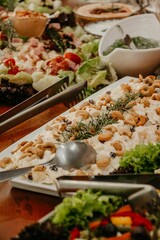 several salads and side dishes on a long table for the food