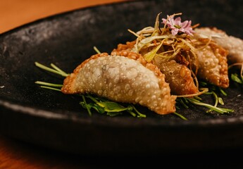 A closeup shot of a black plate with fried dish