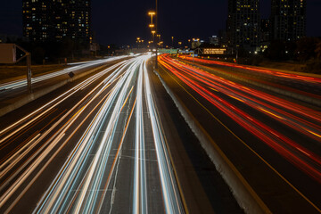 Fototapeta na wymiar Speed traffic, light trails on freeway at night, long exposure abstract urban background. Toronto West highway 427 southbound. High travel speed effect, dui, careless, dangerous, drunk driving concept