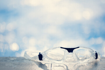 Close-up shot of swimming goggles on swimming pool, text input background in swimming pool.