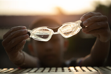 Close-up shot of swimming goggles on swimming pool, text input background in swimming pool.