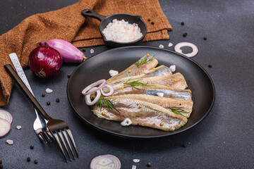 Fillet of pickled marinated sea herring fish with shallots and dill. Cutlery, vintage napkin