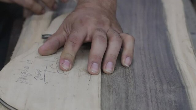 Artisan working on wood making measurements at a workshop place, closeup shot