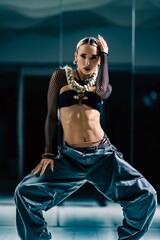 Vertical view of an attractive girl posing before the mirror in a dance studio