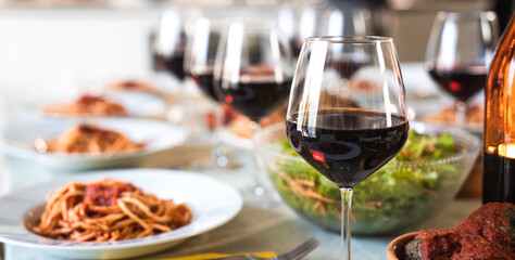 Table set for lunch with genuine products of Italian cuisine like tasty spaghetti with tomato sauce and amazing red wine - Concept of presentation of genuine Italian food famous in the world