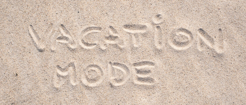 Sand background. Vacation mode written on sand. Sandy beach. Blank negative space for copy. Summer holiday banner.