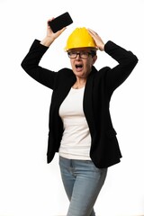 Engineer woman holding a phone with a terrified face expression on white background