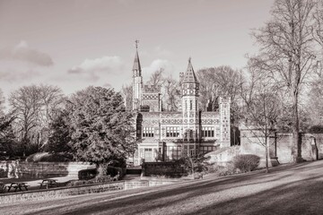 Grayscale of Saltwell tower on a sunny day, autumn landscape around