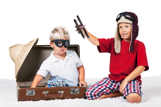 Two boys in the form playing with a toy plane dressed as old school pilots