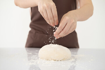 Fototapeta premium Cooking dough by woman hands for homemade pastry bread, pizza, pasta recipe preparation on white table background.copy space