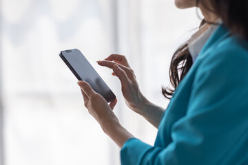 Business Asian woman hold phone and use laptop at the workplace. Project stats financial data sales charts on laptop and cellphone Asian finance concept
