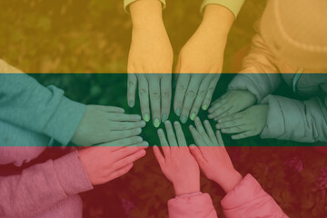 Hands of kids on background of Lithuania flag. Lithuanian patriotism and unity concept.