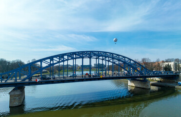 Krakow, Poland. Blue Pilsudski tied-arc bridge and observation and tourist balloon over Vistula River