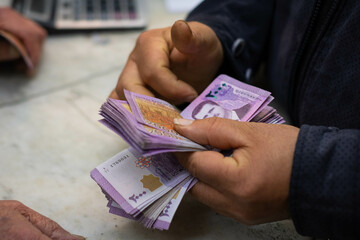 Syrian Lira or Syrian Pound, closeup of a person counting cash money in Syria