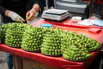 Pile of fresh almonds for sale on street, green almond