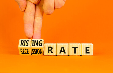 Recession or rising rate symbol. Concept word Recession rate Rising rate on wooden cubes. Businessman hand. Beautiful orange background. Business recession or rising rate concept. Copy space.