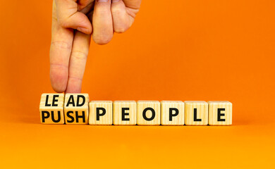 Lead or push people symbol. Concept word Lead people and Push people on wooden cubes. Beautiful orange table orange background. Businessman hand. Business Energy or hunger crisis concept. Copy space.