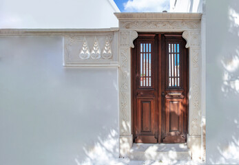 Greece. Tinos island of art, Home entrance door with marble frame on white wall,