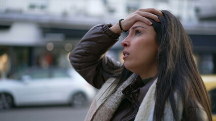 One anxious Middle Eastern young woman walking in street feeling frustrated. Female person in 20s suffering from mental pressure in urban environment sidewalk