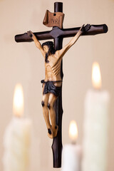 Candles and wooden crucifix on brown background