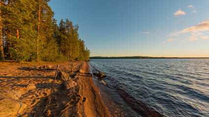 A photography tripod on a beach by a lake in summer in Finland