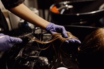 Cropped photo of woman hairdresser hairstylist colorist beautician wearing blue rubber gloves,...
