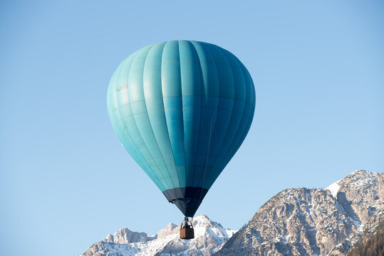 una bella mongolfiera di colore blu in volo sulle dolomiti