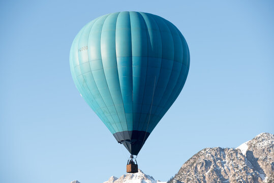 una bella mongolfiera di colore blu in volo sulle dolomiti