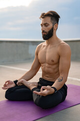 attractive hansome man with athletic strong body doing morning yoga dzen meditation