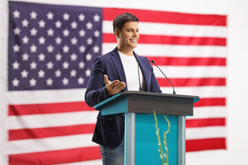 Male speaker giving a speech on a pedestal with the USA flag in the back