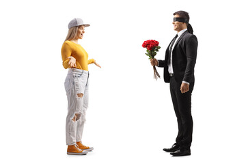 Full length profile shot of a businessman with a blindfold giving a bunch of roses to a young casual female - obrazy, fototapety, plakaty