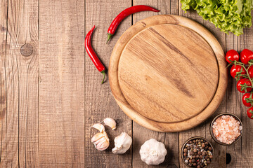 Wooden Cutting Board with Fresh Herbs and Raw Vegetables on Rustic Wood Table. Top view. Cooking...