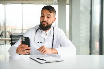 Fototapeta na wymiar Cheerful young arab man doctor having video call with patient