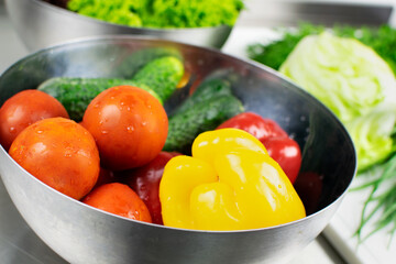 Fresh washed sweet peppers, tomatoes and cucumbers in a metal plate