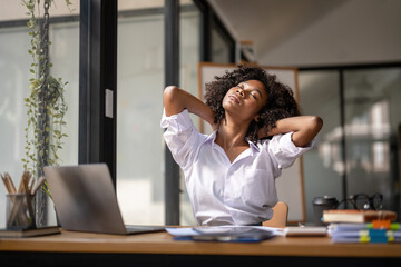 Black woman getting physically active from fatigue sitting at a desk. tired from work, Twisting due...