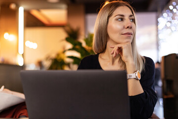 Portrait of young beautiful blond hair woman working with laptop in office or in coffee shop....