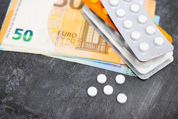 White round pills, blister packs with tablets, antibiotic, painkiller or drugs and money, Euro...