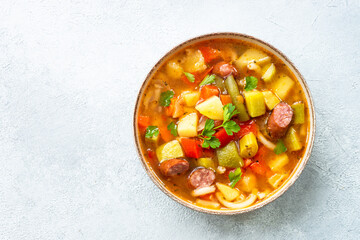 Minestrone soup, italian vegetable soup with smoked sausages, Top view.