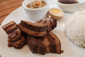 Close up view of Kakuni, Japanese Braised Pork Belly, with rice and soup on white plate. 