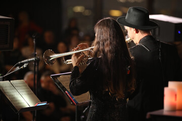 Trumpeter playing a musical instrument in a group of musicians