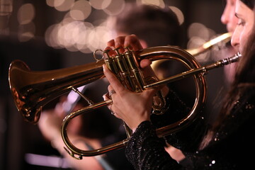 Flugelhorn in the hand of a musician playing a close-up view of a golden musical instrument