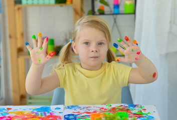 Girl paint fingers drawing baby painting hand therapy children art play. Kids have fun and create picture. Palms of different colors. Sensory development and experiences