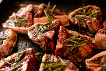 raw lamb chops on a metal tray 