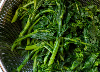 broccoli rabe in a food strainer 