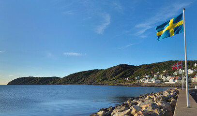 Swedish and Norwegian flags hoisted on mats on the coast of a village