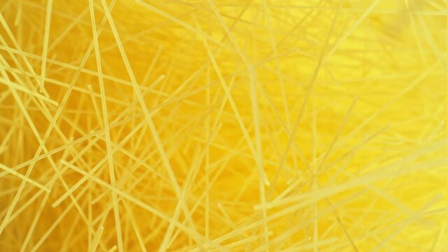 Super slow motion of flying uncooked italian pasta spaghetti on golden background. Filmed on high speed cinema camera, 1000 fps.