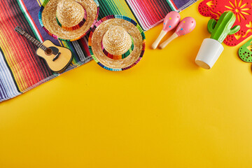 Cinco de Mayo holiday background. Maracas, cactus and hat on yellow background.